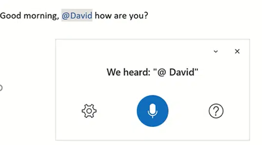 Screenshot showing the @mention voice command feature in Outlook's email dictation functionality